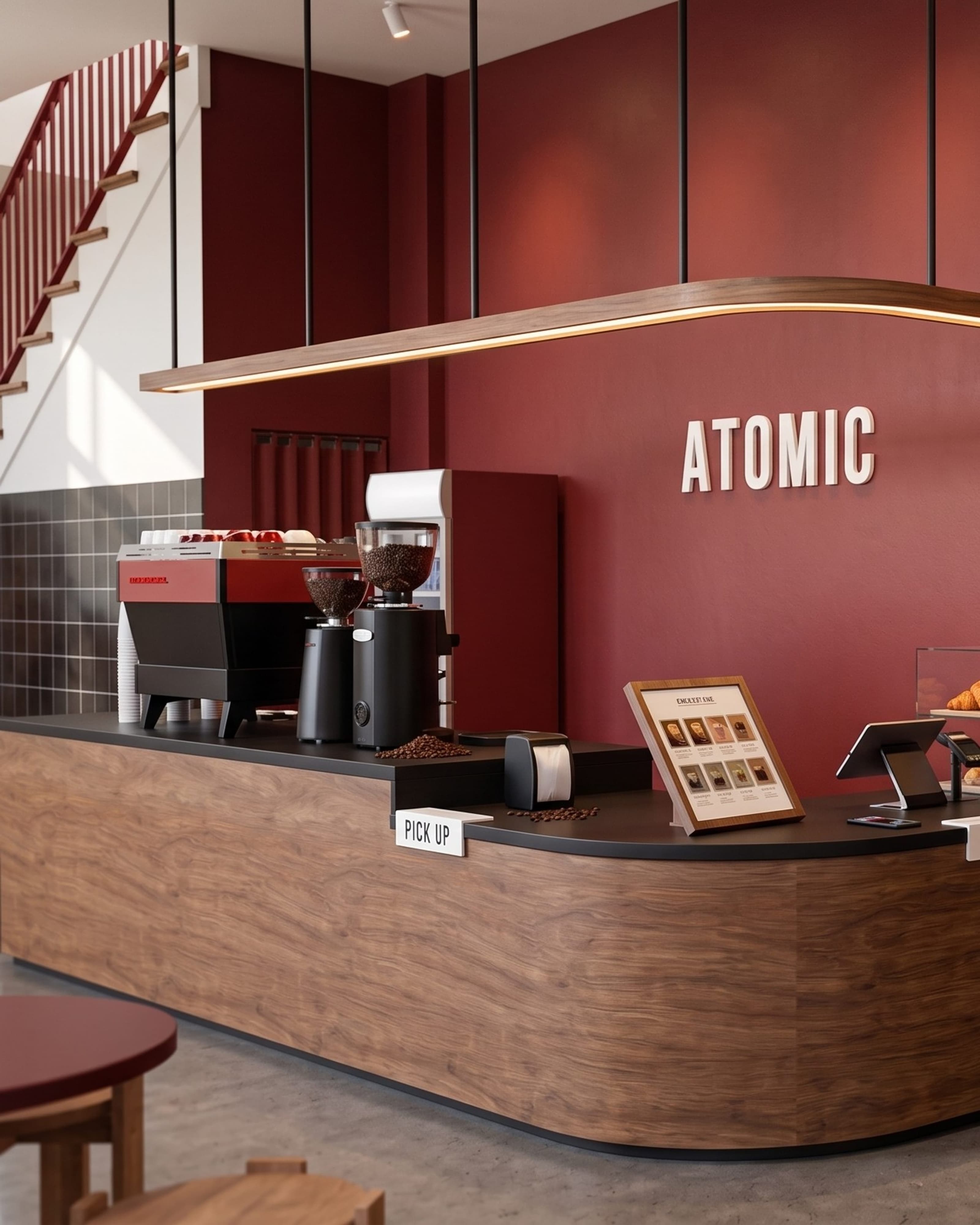 Atomic Cafe counter with a bold red accent wall, illuminated signage and a pastry display.